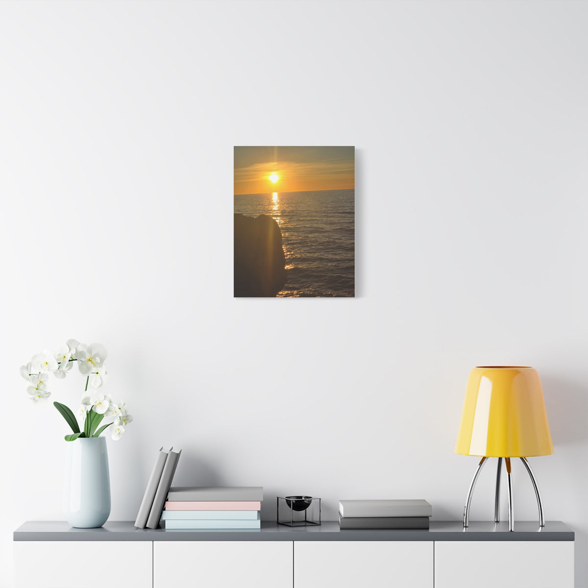 Break Wall Ocean View canvas print — coastal sunset wall art displayed on a white wall above a console table with yellow lamp