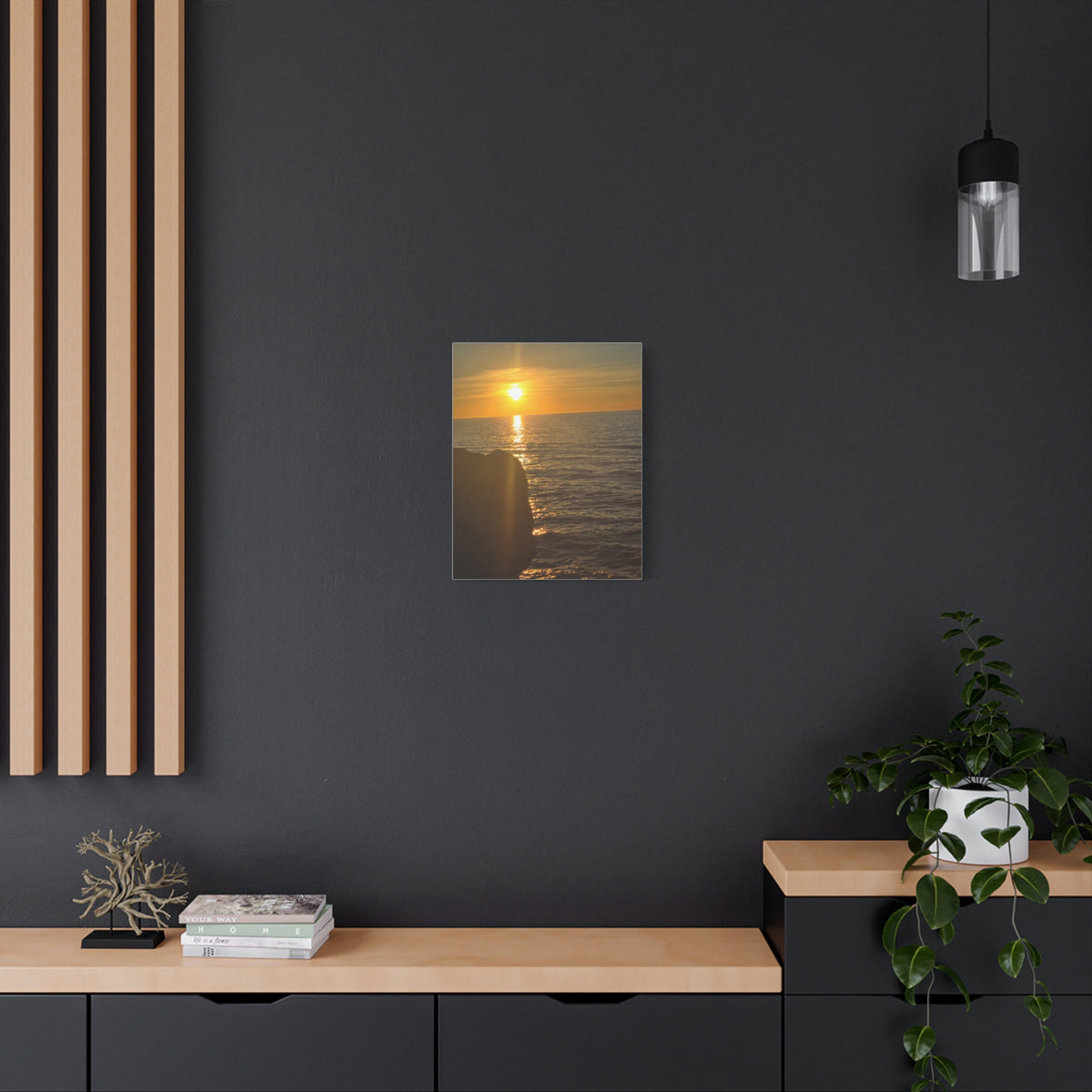 Break Wall Ocean View canvas print — glowing ocean sunset canvas in a dark-toned modern room with wood credenza